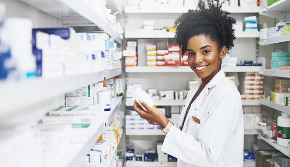 Female-pharmacist-holding-medication-and-smiling