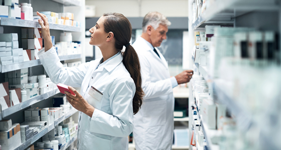 Male-and-female-pharmacists-looking-at-medication-on-shelves-at-a-hospice-pharmacy-in-Long-Beach
