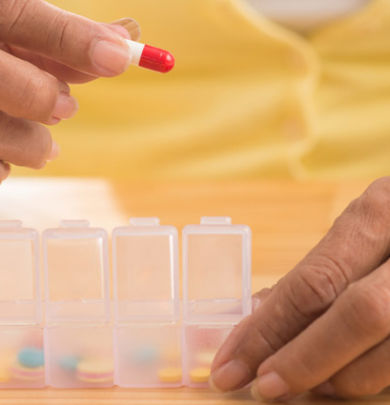 Caretaker-organizing-medication-into-a-pill-box
