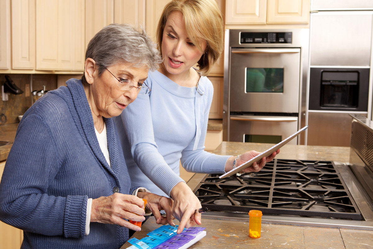 Female-caregiver-instructing-senior-woman-how-to-take-medication