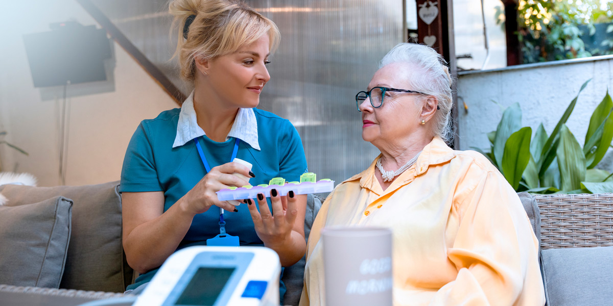 Female-nurse-helping-female-hospice-patient-with-medication